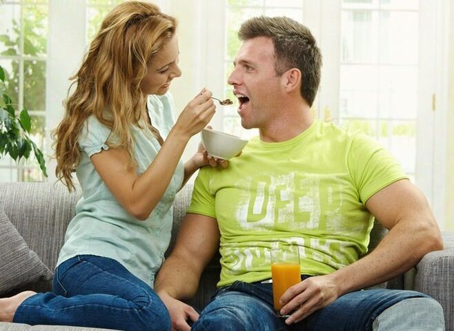 La donna nutre l'uomo con prodotti per aumentare la potenza